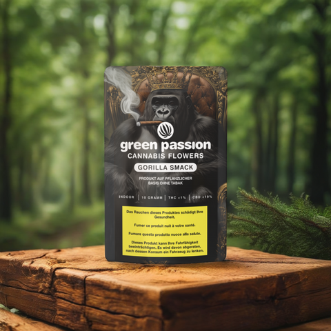 Nahaufnahme der Gorilla Smack CBD-Blüten von Green Passion – edle Verpackung mit markantem Gorilla-Design, stilvoll inszeniert auf einem Holztisch mit natürlicher Waldkulisse im Hintergrund.