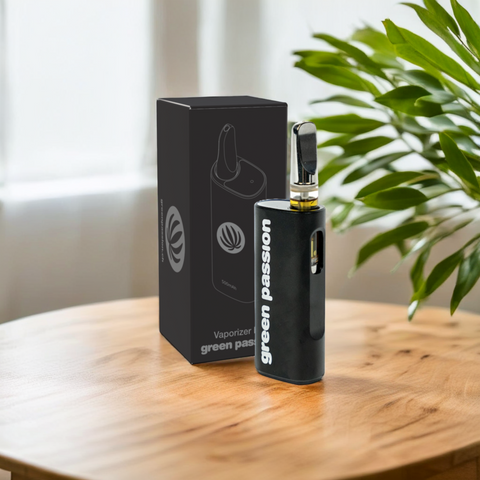 Nahaufnahme des CBD CCELL Vape Pen von Green Passion – stilvoll präsentiert auf einem Holztisch mit dekorativen Pflanzen im Hintergrund, hochwertiger Vaporizer mit 500mAh-Akku und moderner Verpackung.